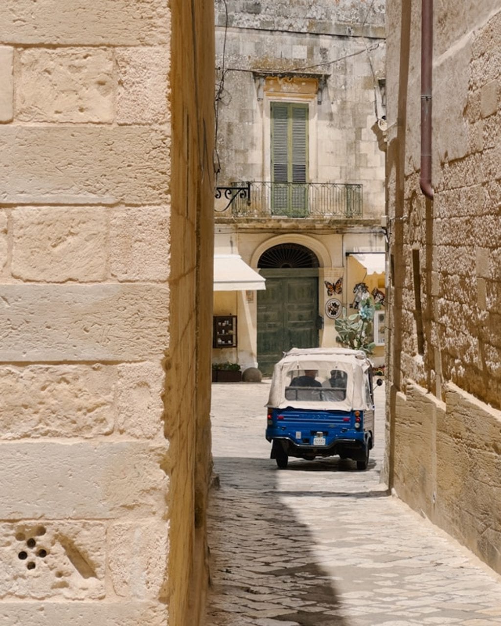 A traditional trullo with a Vespa parked outside in Alberobello