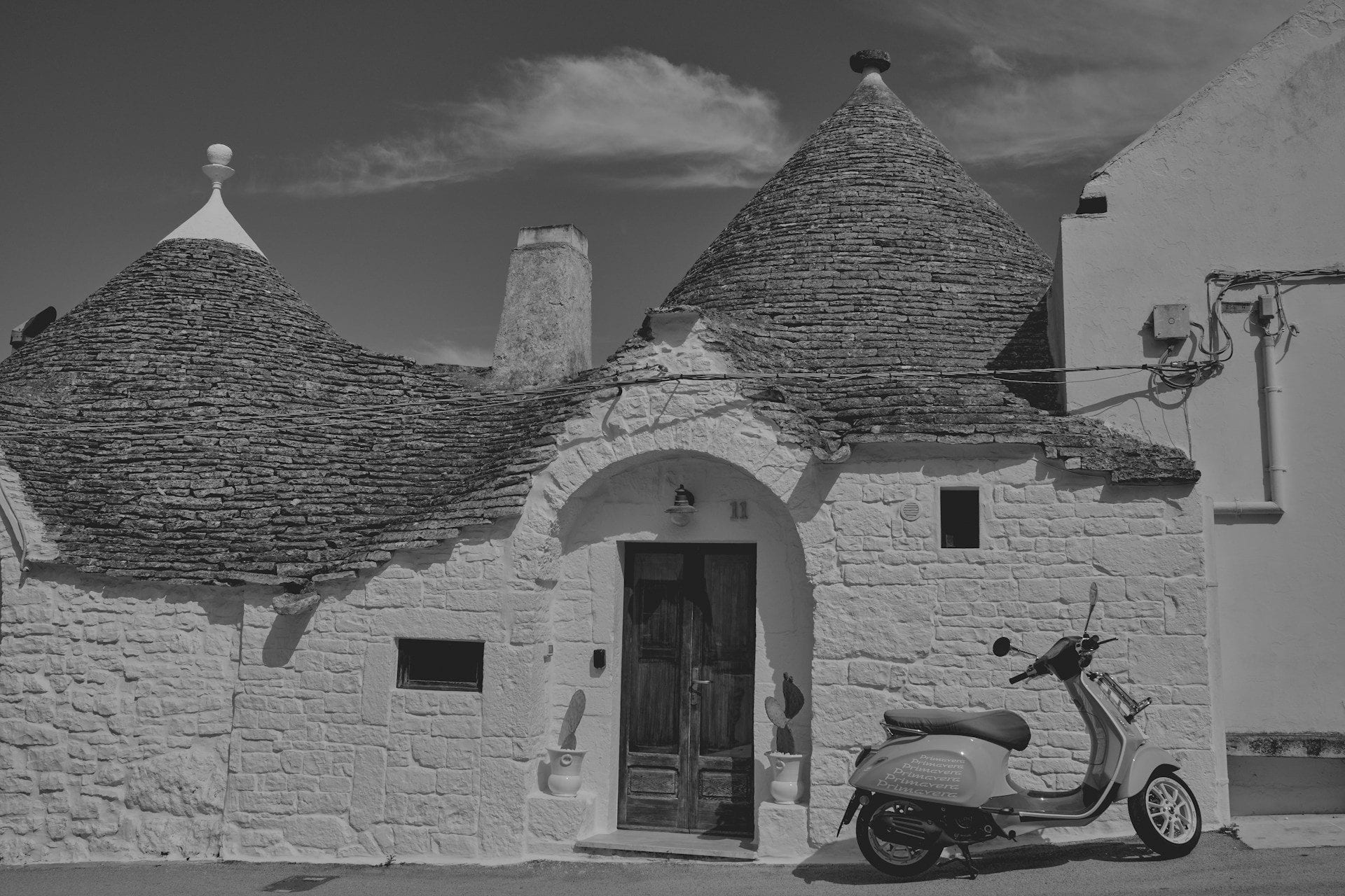 A limestone alley in an old Apulian village with a vintage blue Ape truck