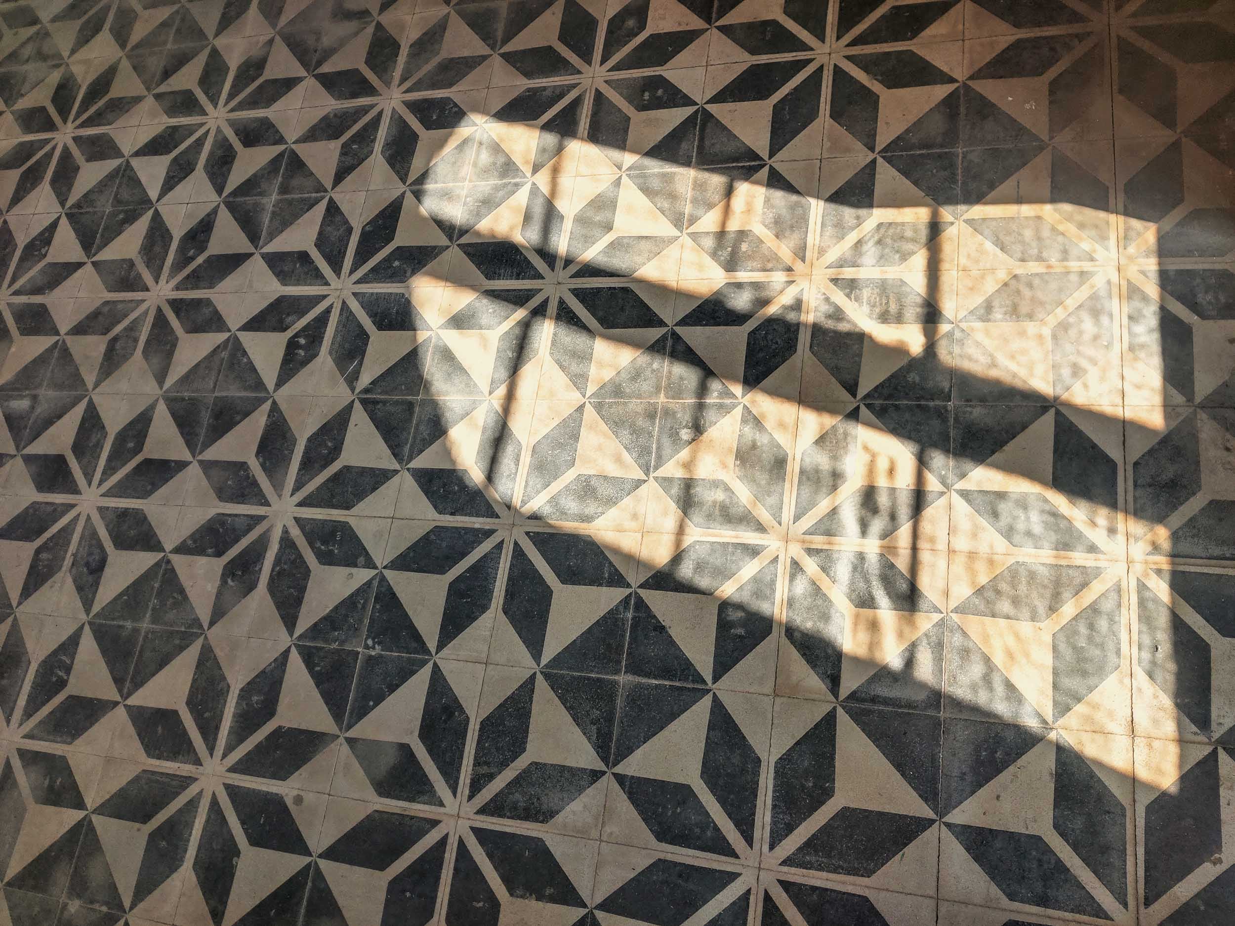 Ornate tiled floor at Palazzo Ceraselli, lit by window light
